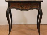 a small table with a marble top on a wooden floor