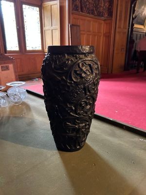 un vase noir posé sur une table dans une pièce