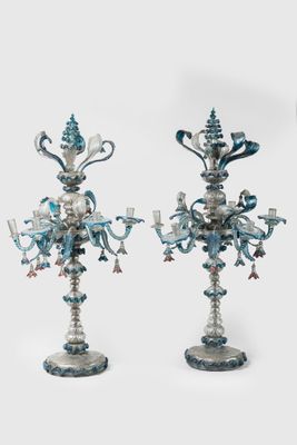 pair of blue and white candelabs with flowers and candles