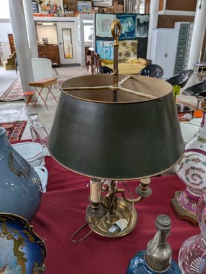 une table sur laquelle se trouvent une lampe, des vases et d'autres objets