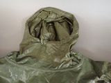 a green jacket with a hood on it sitting against a wall