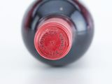 a close up of a bottle of wine on a white surface