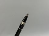 a close up of a pen on a white surface with a gray background