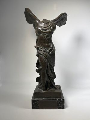bronze statue of a woman holding a fan on a marble base