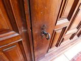a close up of a door handle on a wooden cabinet