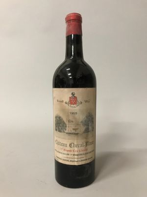 une vieille bouteille de vin posée sur une table blanche