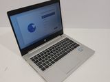 the laptop is sitting on a white table with a blue screen