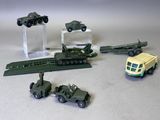 Plusieurs véhicules militaires miniatures et autres véhicules sont posés sur une table