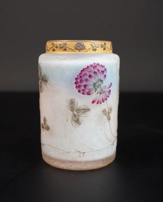 un vase blanc orné de fleurs violettes, posé sur une table