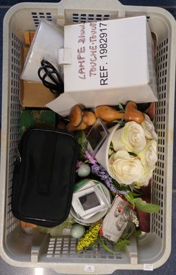 a plastic basket filled with assorted items on the floor