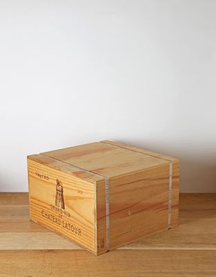 a wooden box sitting on a table next to a plant