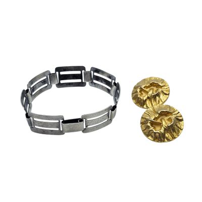 a close up of a bracelet and a pair of earrings on a white background