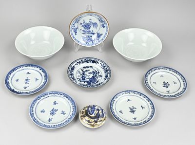 Plusieurs assiettes et bols bleus et blancs sont disposés en cercle.