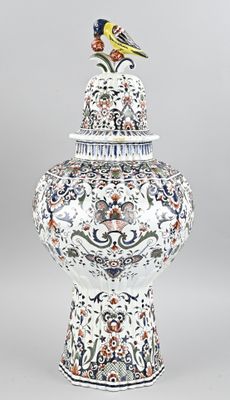un oiseau perché sur un vase posé sur une table