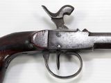 an old gun with a wooden handle on a white surface