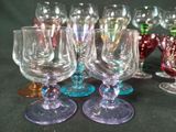 many different colored wine glasses sitting on a table