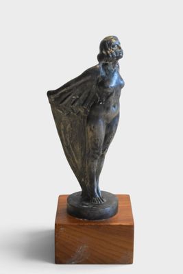 statue of a woman holding a umbrella on a wooden base