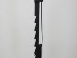a black and gold floor lamp with a black shade on top of it