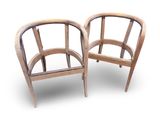 two wooden chairs sitting next to each other on a white surface