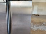 two stainless steel refrigerators sitting on a pallet in a warehouse