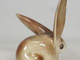 a brown and white rabbit figurine sitting on a white surface