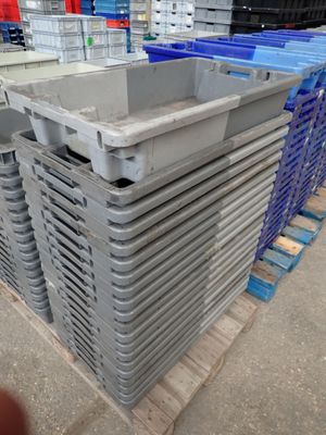 une pile de caisses en plastique posées sur une palette dans un entrepôt