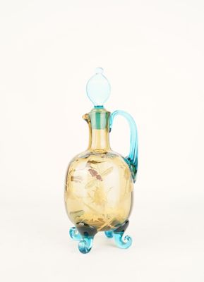 a glass vase with a blue handle on a white background