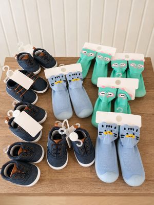 de nombreuses paires de chaussures et de chaussettes pour bébé posées sur une table