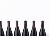 six bottles of wine are lined up in a row on a table