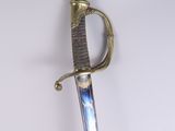 an old sword with a gold handle on a white surface