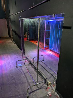 a mirror that is sitting on a stand in a room