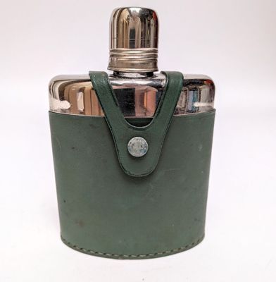 une gourde en cuir vert avec un bouchon en argent