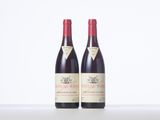 two bottles of red wine sitting next to each other on a table