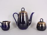 three pieces of blue and gold tea set on a white surface