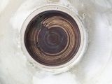 a close up of a white vase with a brown center