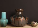 trois vases posés sur une table l'un à côté de l'autre