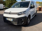 la camionnette blanche est garée dans un parking avec d'autres véhicules