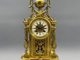 a gold clock sitting on top of a table