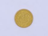 a close up of a gold coin on a white surface