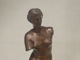 bronze statue of a woman sitting on a marble base