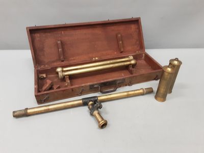 un vieux tuyau en laiton et des raccords en laiton dans un coffret en bois