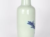 a white vase with blue designs on it on a white surface