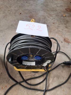 une bobine de fil électrique posée par terre, avec une étiquette de prix