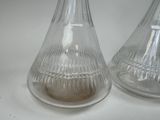 two glass vases with a small candle inside of them