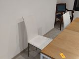 tables and chairs in a room with a window and a chair