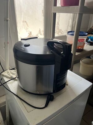 a silver and black food processor sitting on top of a white refrigerator