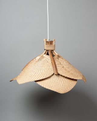 un gros plan d'une lampe suspendue à une corde sur un fond gris