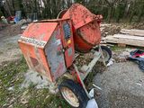 une bétonnière posée par terre à côté d'un tas de bois
