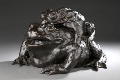 une statue représentant une grenouille assise par terre