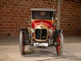 a red and gold car parked in front of a brick wall